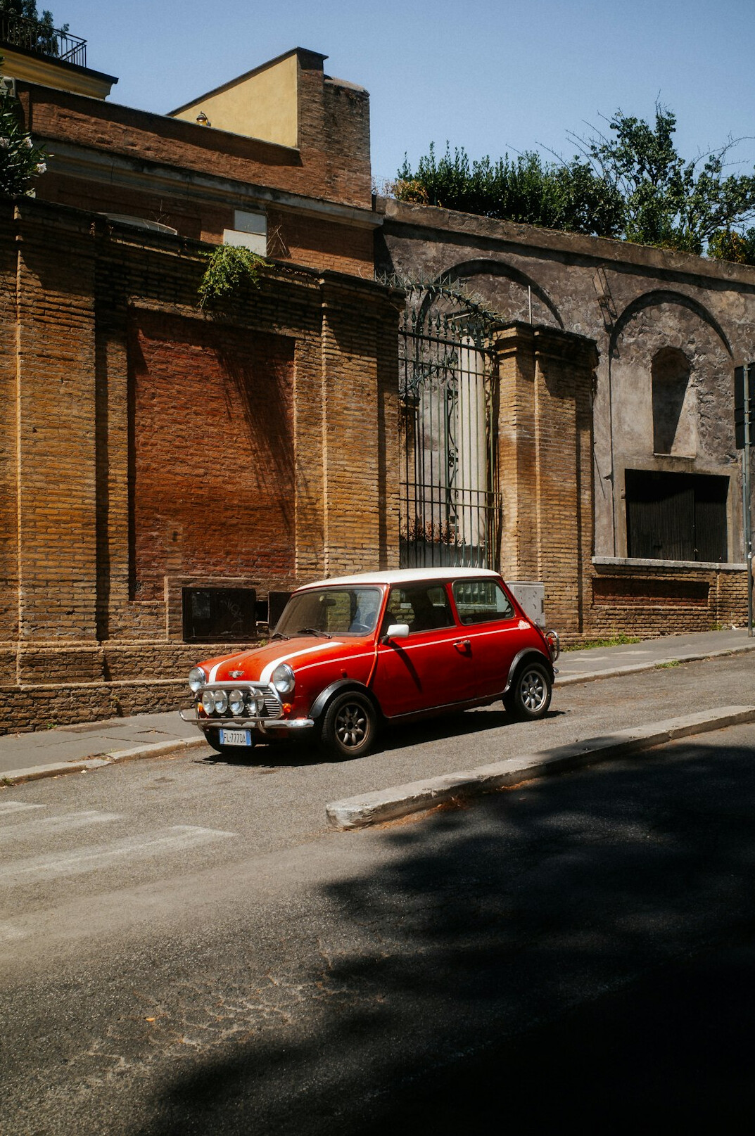 Red vintage Italian sports car parked on an old street