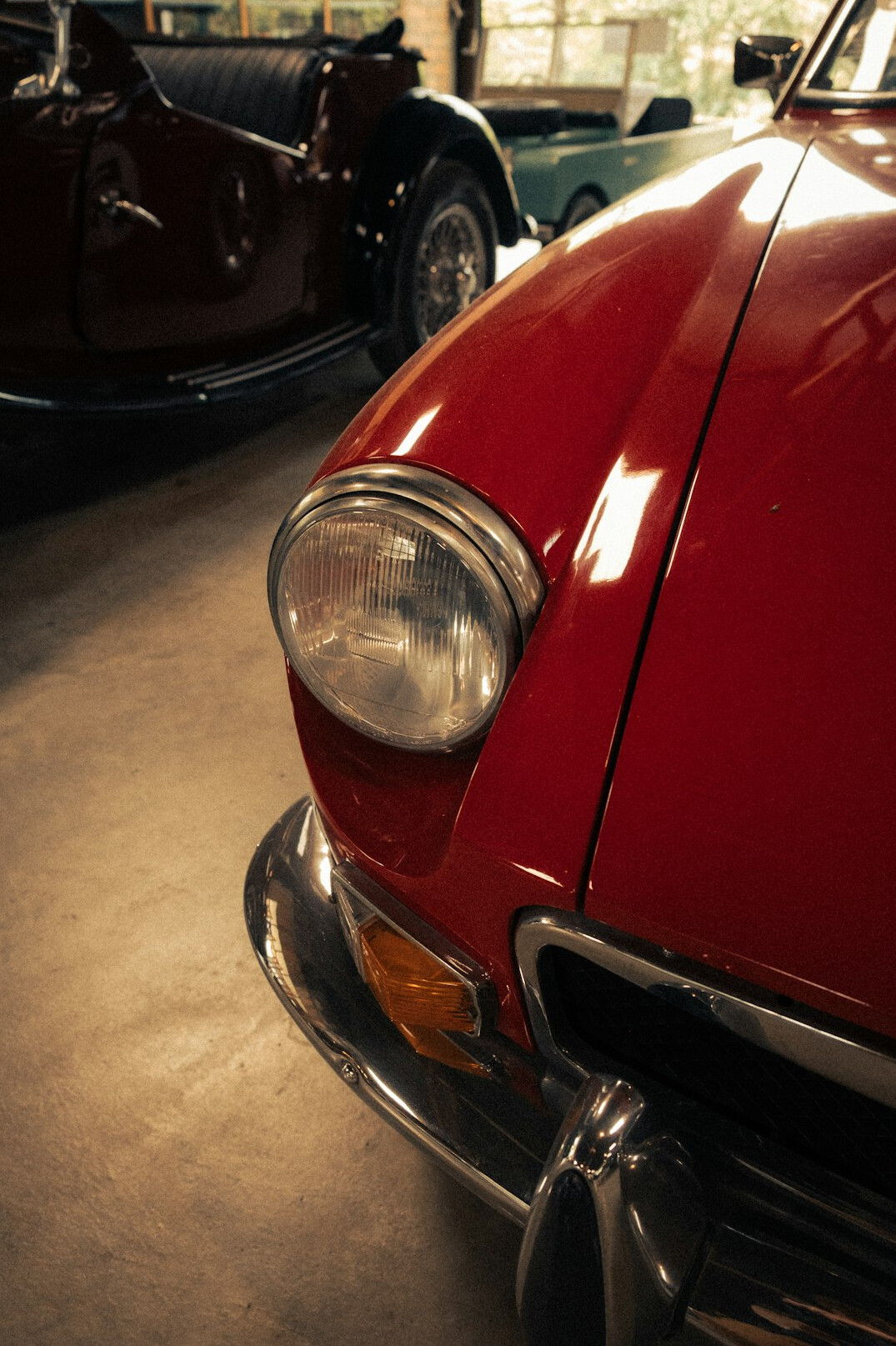 Private collection of vintage automobiles in a dim garage