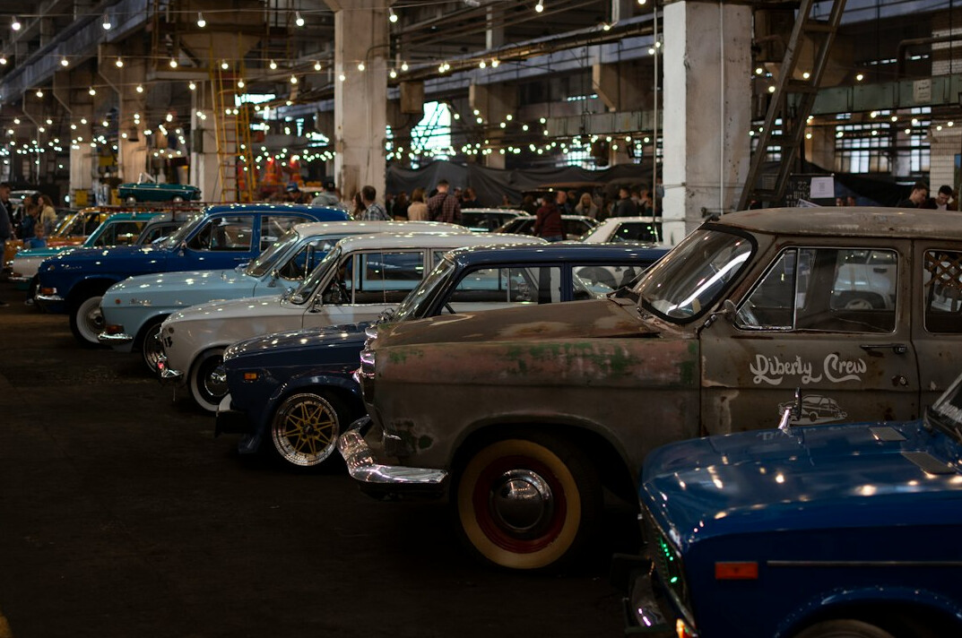 Interior of a classic car exhibition hall with spotlighted vehicles
