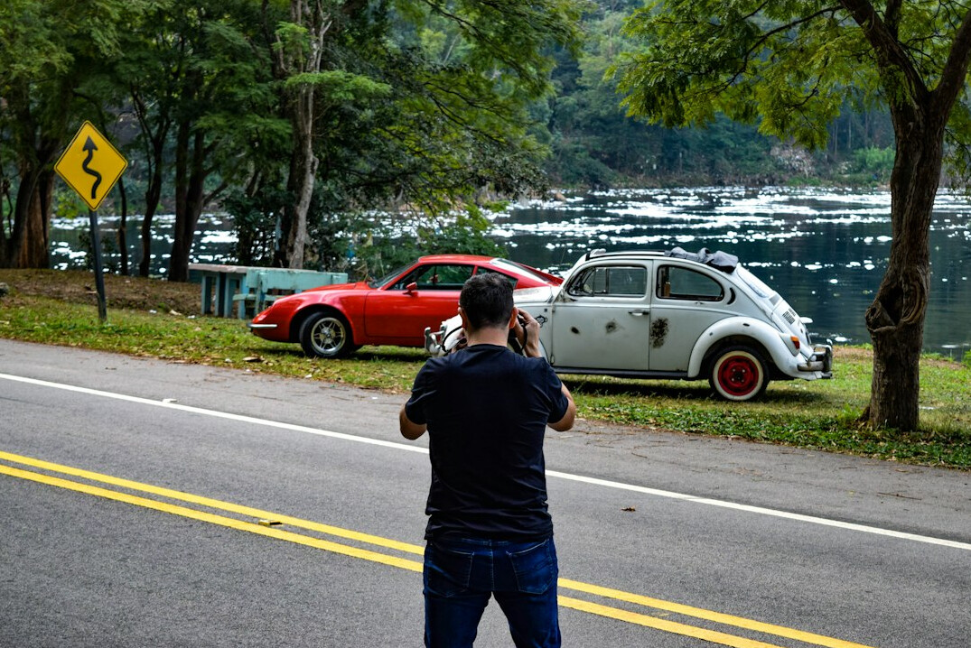 Photographer capturing a classic car with a camera